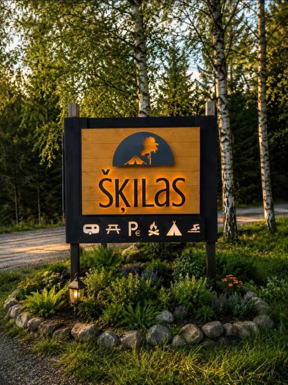 a sign for a skiias resort in a park at Šķilas in Pērkone