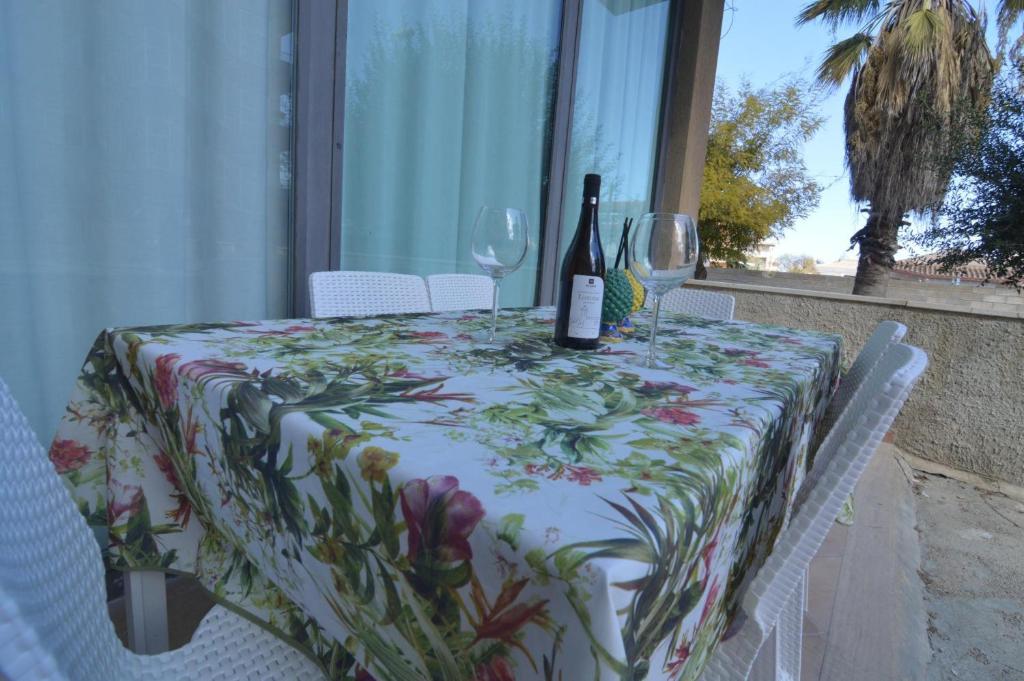 a table with a bottle of wine and two glasses at Loredana's House in Pachino