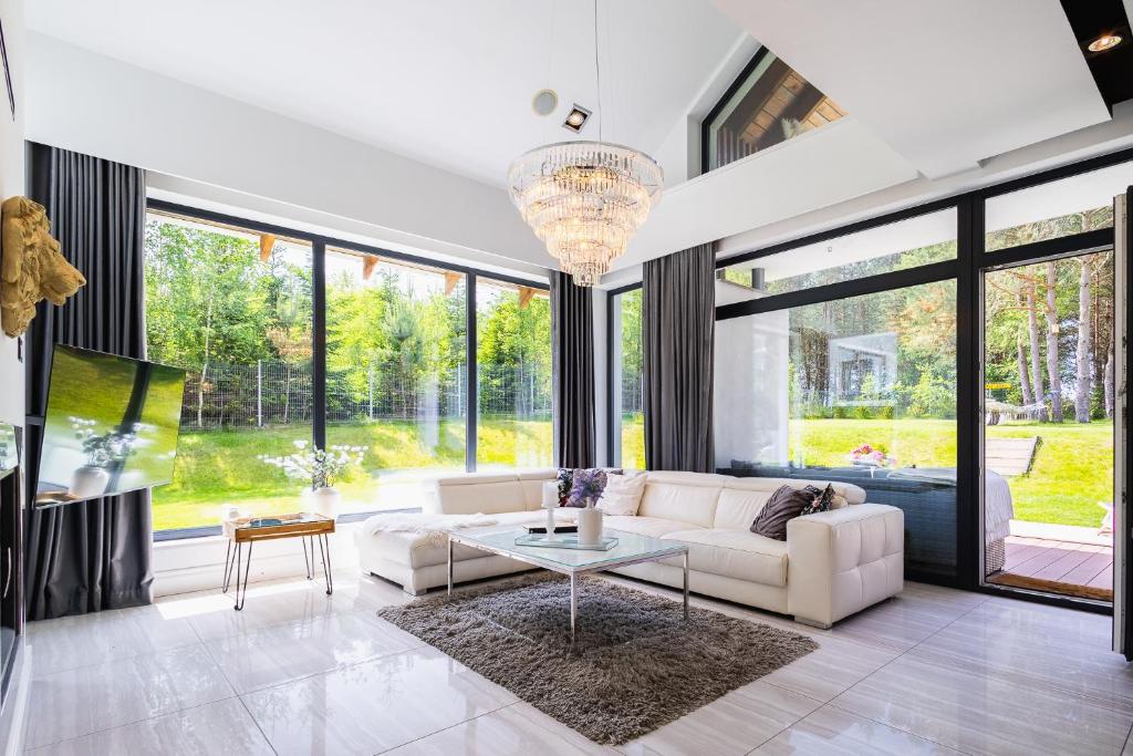 a living room with a white couch and a table at Willa Vivaldi - Family & Friends - Sauna, Balia in Grzybowo