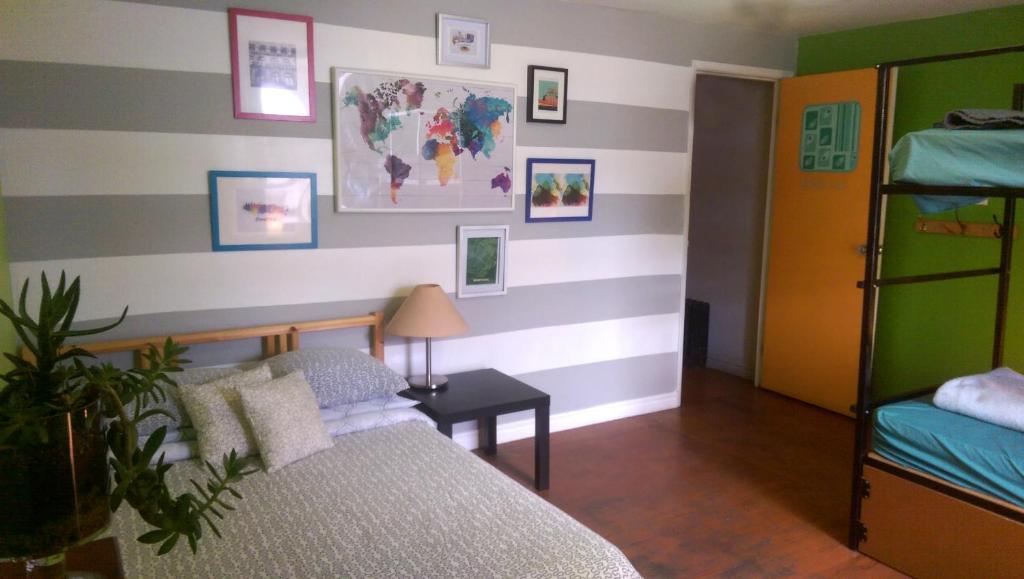 a bedroom with a bed and a striped wall at Auberge Alternative in Montreal