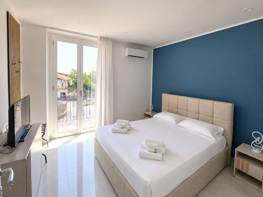 ein Schlafzimmer mit einem großen weißen Bett und einer blauen Wand in der Unterkunft Etnera in Trecastagni