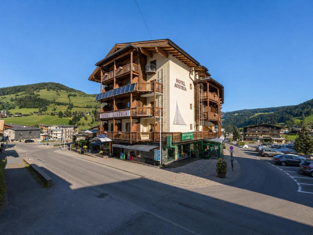 a tall building on a street with a parking lot at Hotel Austria Wildschönau & Wildschönau Premium Card in Niederau