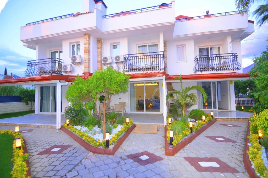 a white house with a courtyard in front of it at Fethiye Cagri Pansiyon in Fethiye