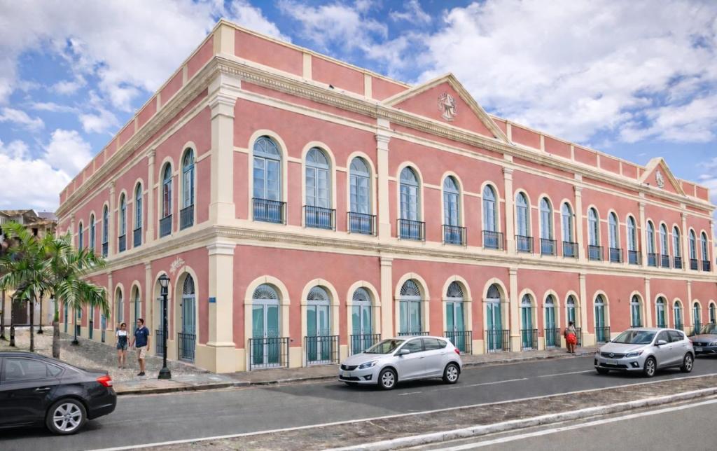 a large pink building with cars parked in front of it at Vila Galé Collection Opera - Sao Luis in São Luís