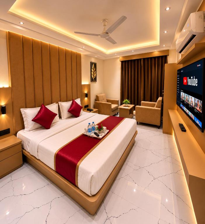 a hotel room with a large bed and a flat screen tv at Hotel The Sun B&B in New Delhi