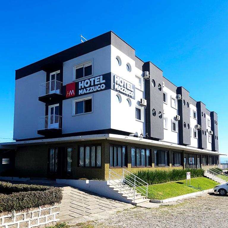 a hotel with a sign on the side of a building at Hotel Mazzuco in Araranguá