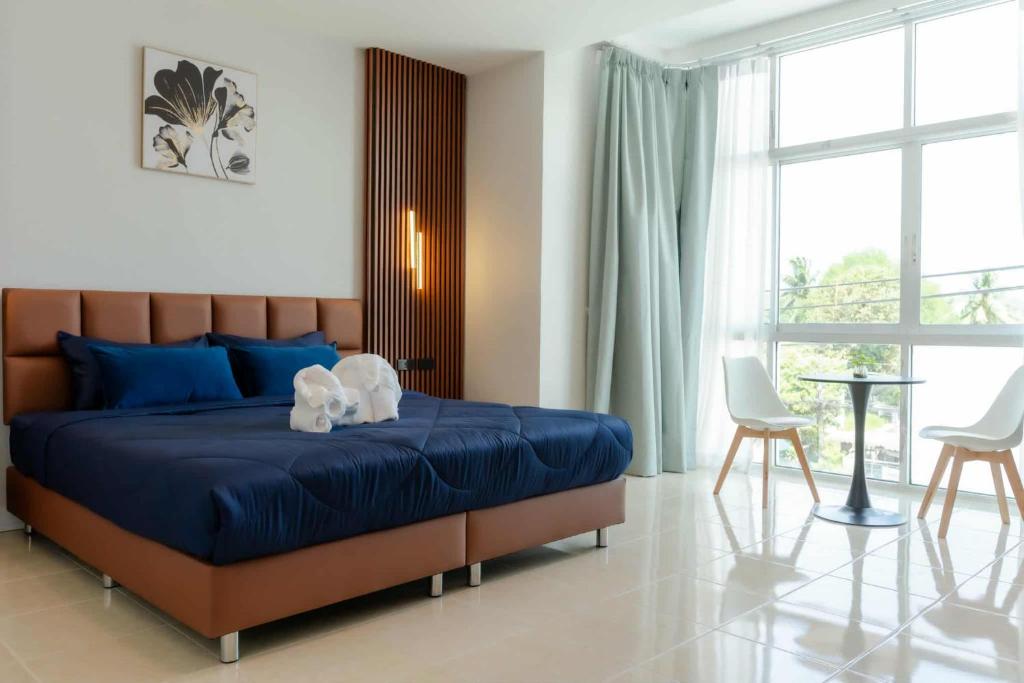 a bedroom with a blue bed and two chairs at PGD brown city view in Rawai Beach