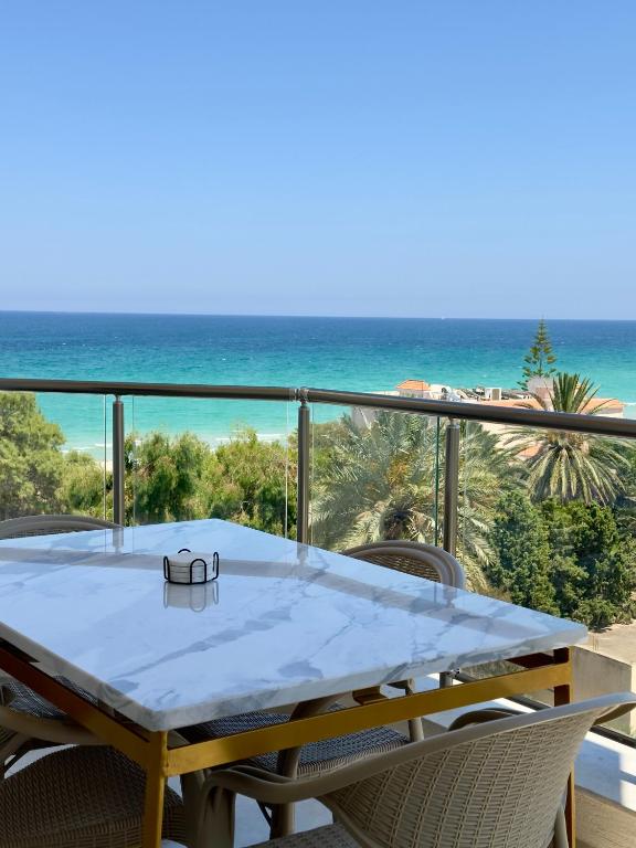 a table on a balcony with a view of the beach at Apartment with sea view and pool access in Chott Meriem