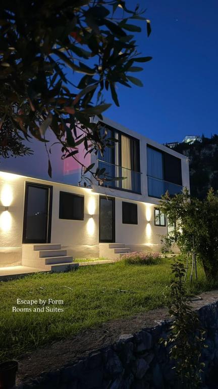 a house with lights on the side of it at Escape Suites in Dhërmi