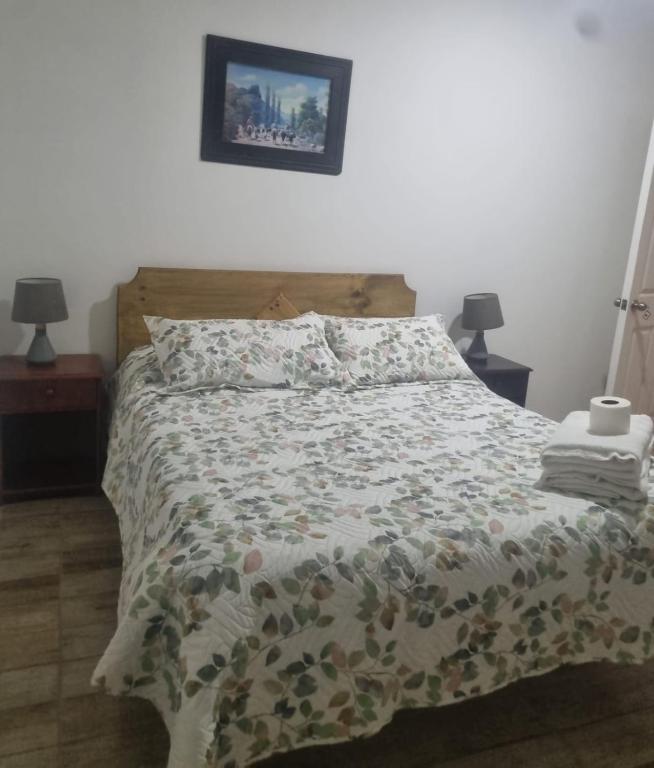 a bedroom with a bed with a floral comforter at Hotel santa Rosa 2 in Ovalle