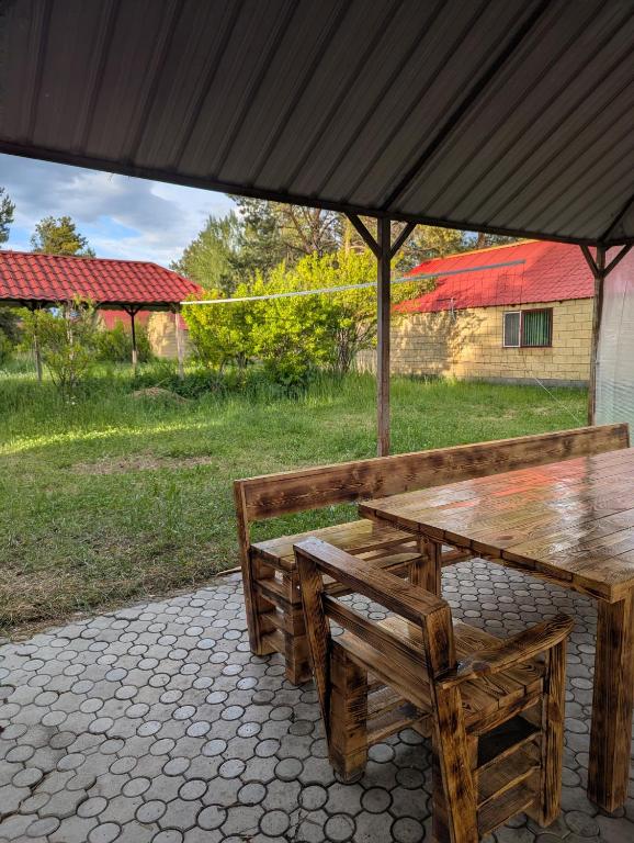 a wooden table and two benches under a tent at Sevan Grass and Sky in Sevan