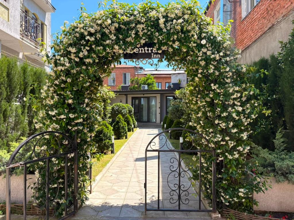 an entrance to a building with an arch covered in flowers at Central Inn in Kutaisi