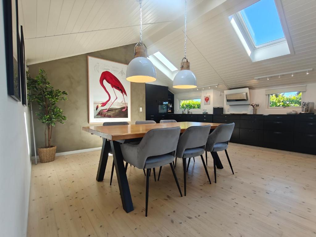 a dining room with a wooden table and chairs at Natur, fjord og hygge nær Roskilde in Kirke-Hyllinge