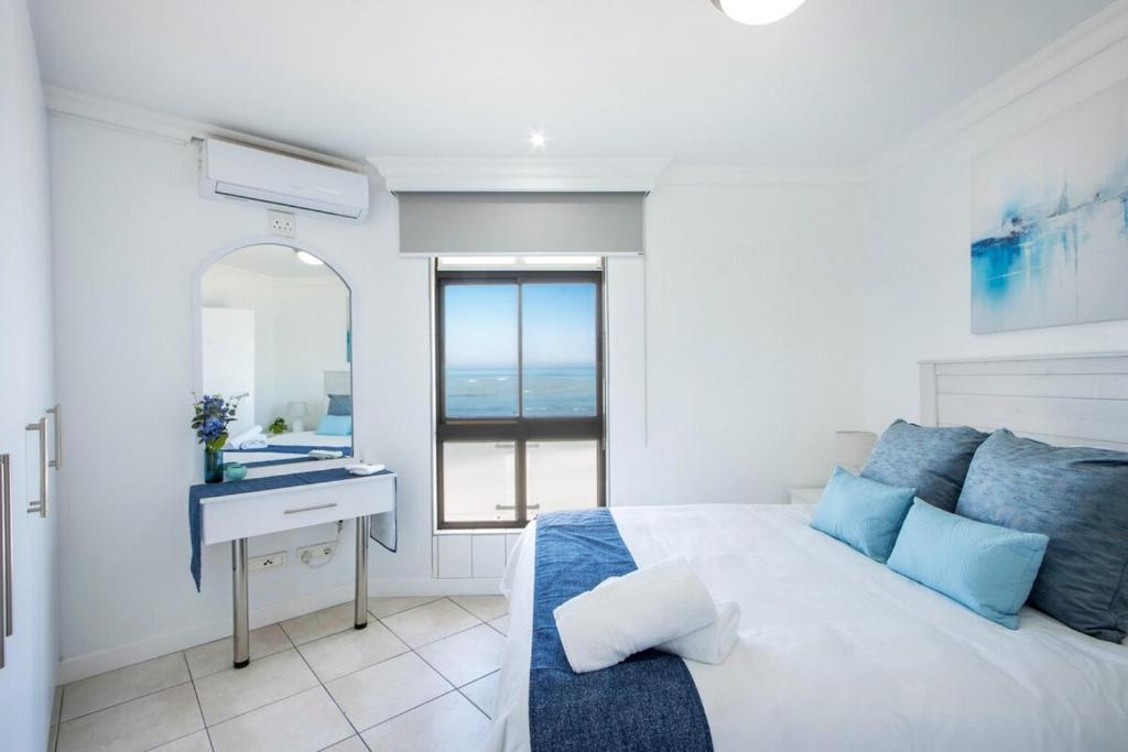 a bedroom with a bed and a sink and a mirror at Hibernian Towers 408 in Strand
