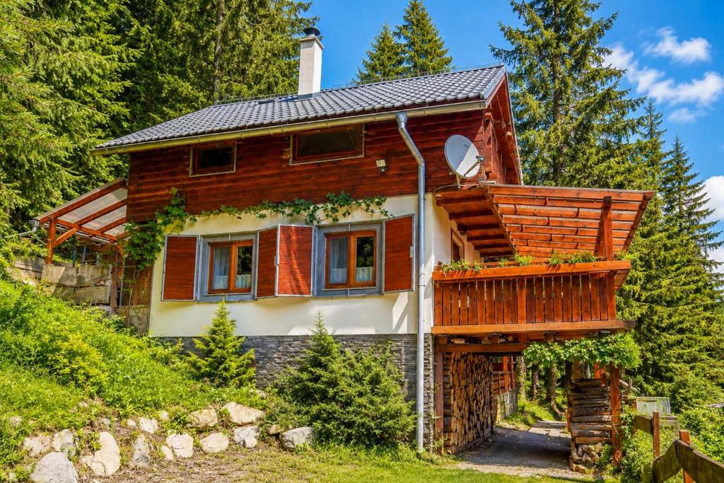 a wooden house with a balcony on a hill at Norova chata in Závažná Poruba