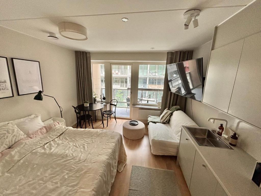 a bedroom with a bed and a sink and a table at Perfect cosy living in Stockholm