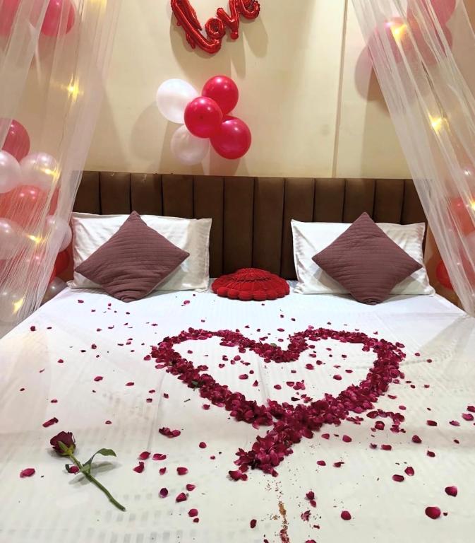 a heart made out of flowers on a bed at Jk hotel in Hisār