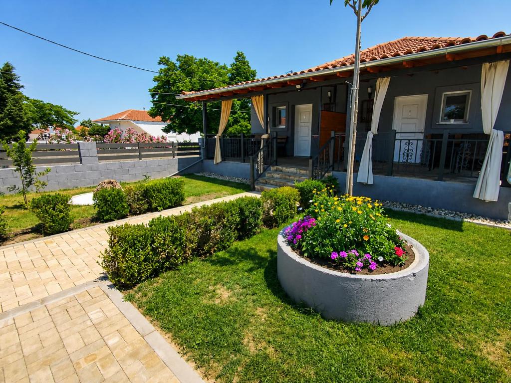 a house with a garden with flowers in the yard at Stella's House Mangana in Mángana