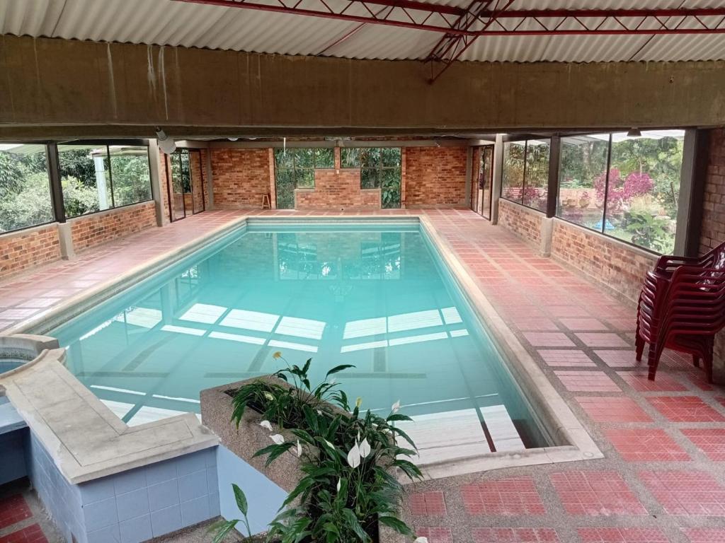 a swimming pool in a house with a patio at Touristic House Chalet Luna Verde in Sasaima