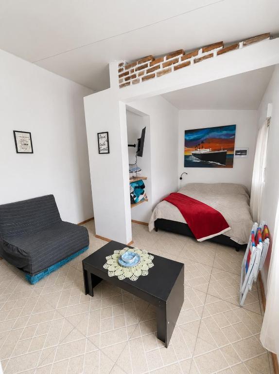 a bedroom with a bed and a table in a room at Alojamiento EYO en Chuy con Baño Privado y Aire Acondicionado in Chuy