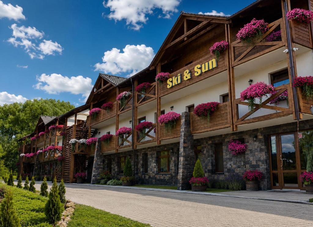 a building with flowers on the side of it at Ski & Sun Wellness Apartments in Liptovský Mikuláš