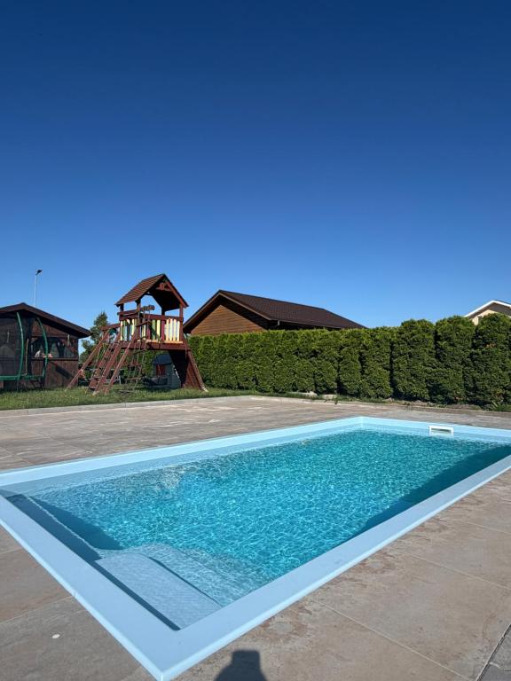 a swimming pool in a yard with a playground at KARMAZYNOWY RAJ in Dąbki
