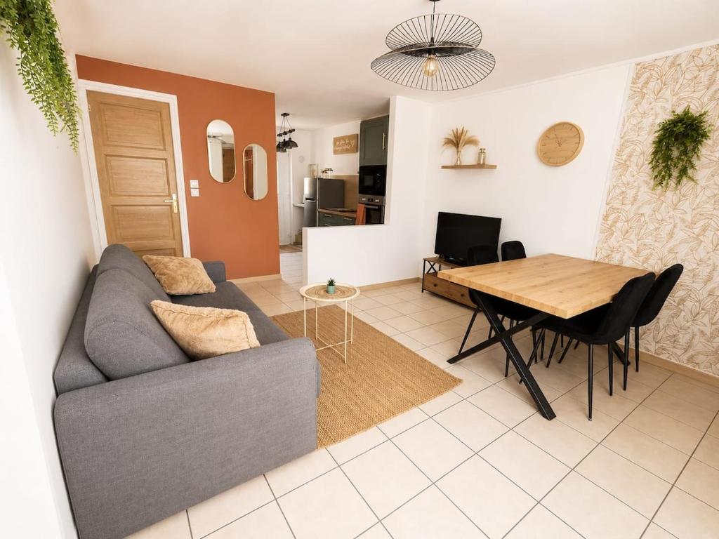 a living room with a couch and a table at La petite maison secrète in Abbeville