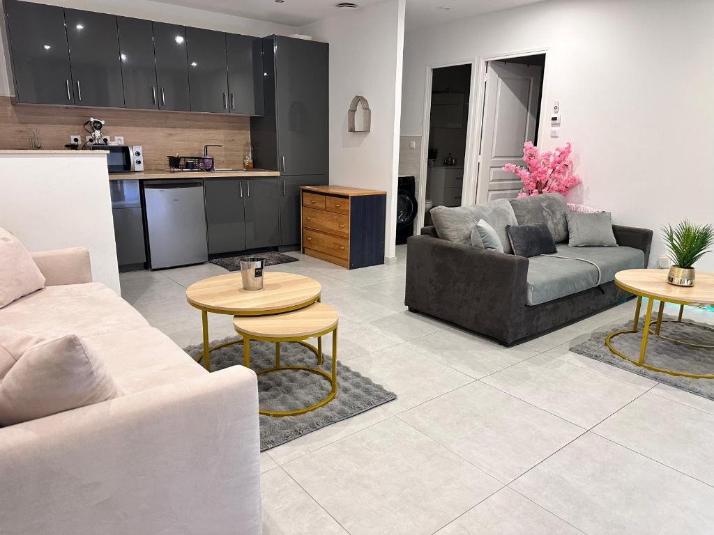 a living room with couches and tables and a kitchen at Paris Giverny familles & professionnels in Freneuse