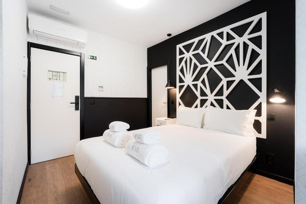 a bedroom with a large white bed with towels on it at The Twenties by GuestReady in Lisbon