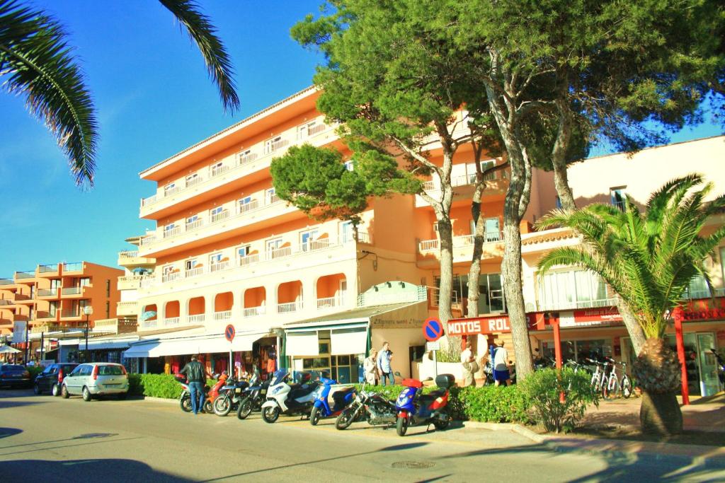 una calle con motocicletas estacionadas frente a un edificio en Hostal Alcina en Cala Ratjada