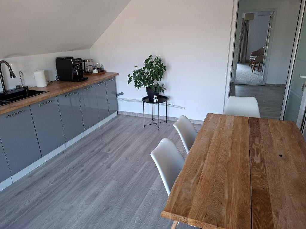 a kitchen with a wooden table and white chairs at Casa Nițică in Vaslui