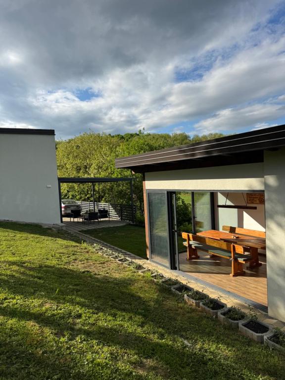 a house with a wooden deck and a picnic table at La casa de Nora in Duga Resa