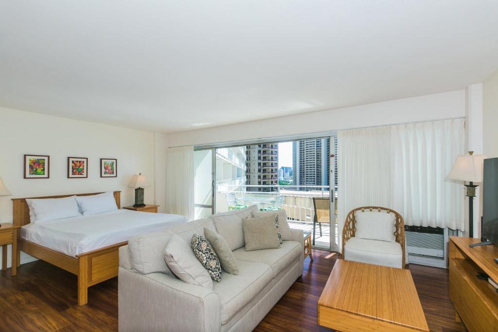 a living room with a white couch and a bed at Ilikai Tower 1228 in Honolulu