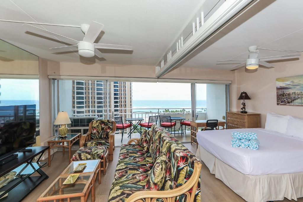 a bedroom with a bed and a living room with a balcony at Ilikai Tower 1314 in Honolulu