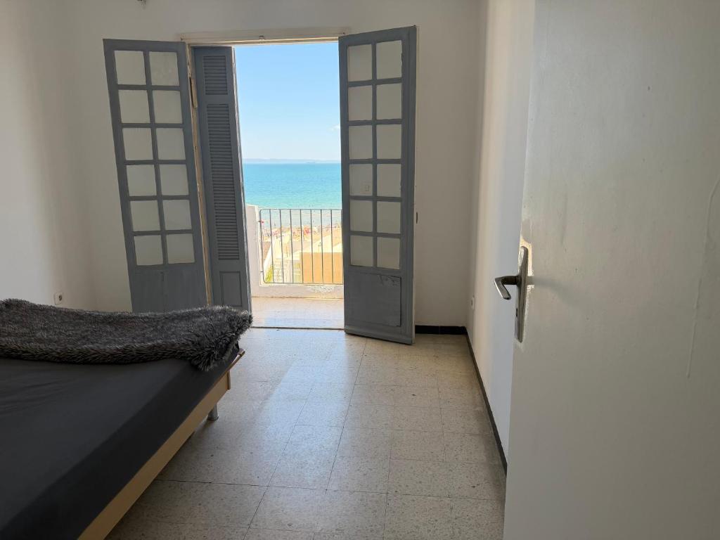 a door leading to a room with a view of the ocean at Complexe la brise tour 8 appt 815 in La Goulette