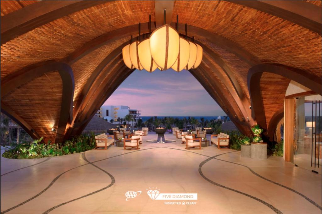 a view of a building with tables and chairs at Secrets Playa Blanca Costa Mujeres - All Inclusive Adults Only in Cancún