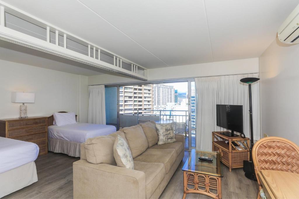 a living room with a couch and a bed at Ilikai Tower 1403 in Honolulu