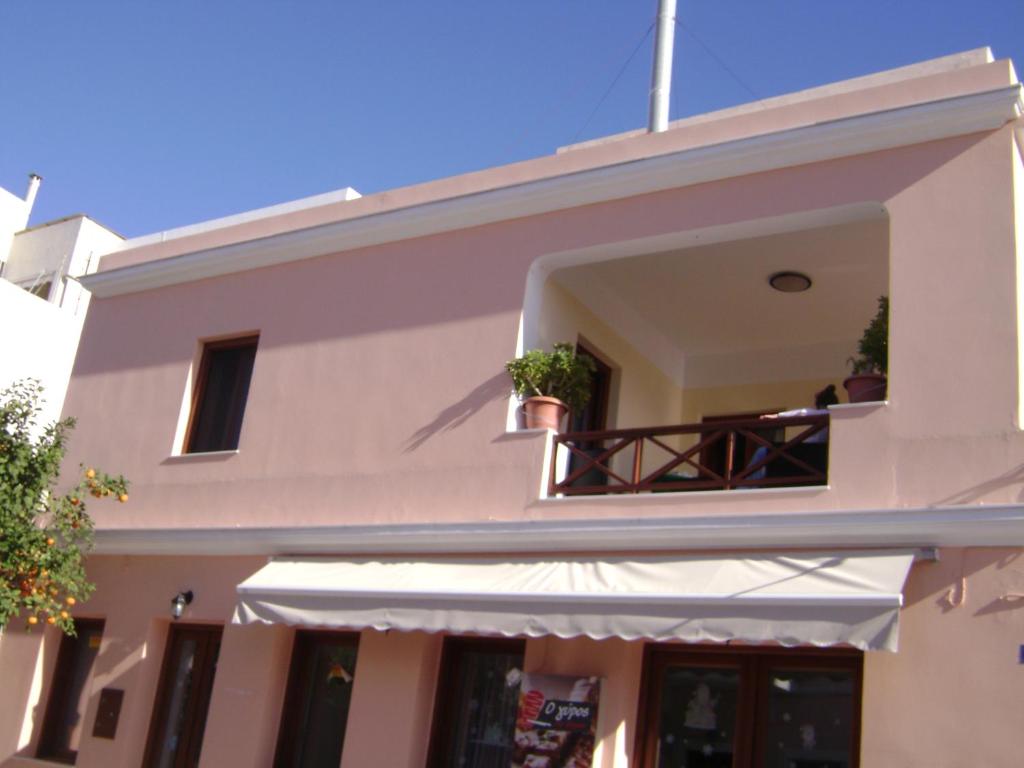 a building with a balcony with potted plants on it at Voula in Ermoupoli