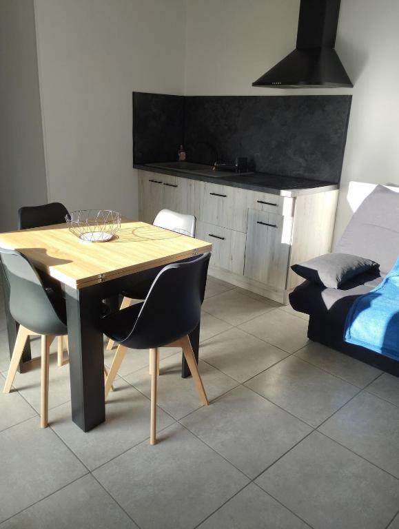 a dining room with a table and chairs and a bed at L'Uzerois in Uzer