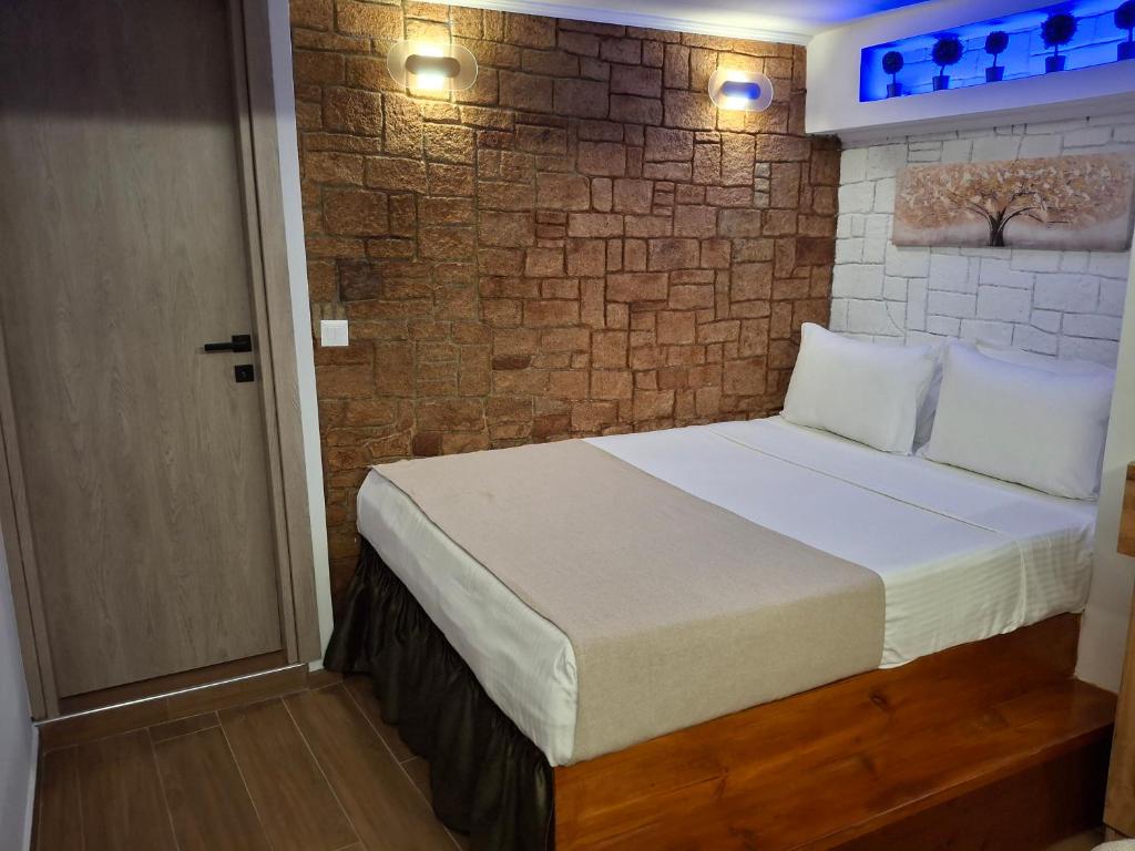 a bedroom with a bed and a brick wall at Luxury Private Suite in Rhodes Town