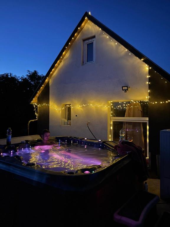 a man in a jacuzzi in a house with lights at Csillagkapu Vendégház in Kápolnásnyék