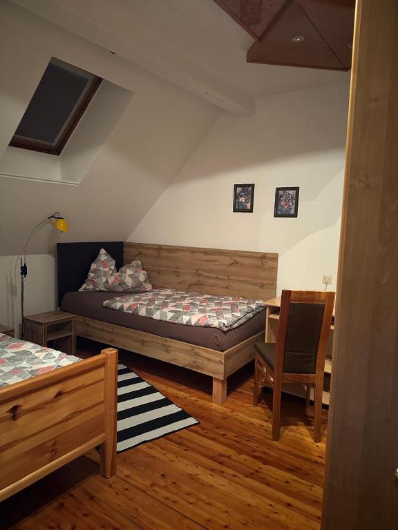 a room with two beds and a table and a chair at Haus Brandner Judenburg in Judenburg