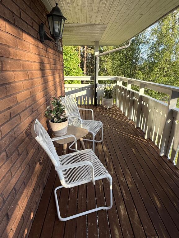 a wooden deck with chairs and a table on it at Villa Älva i Sälen in Sälen