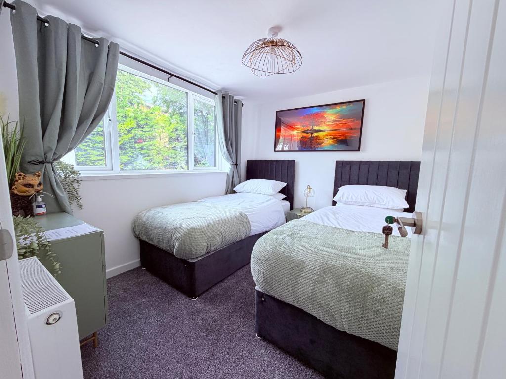 a bedroom with two beds and a window at Anex Highfield Guest House in Idle
