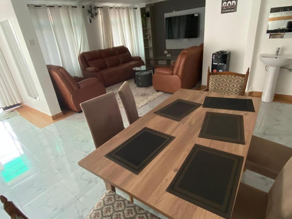 a living room with a wooden table and chairs at Shawn's Hub in Ruaka