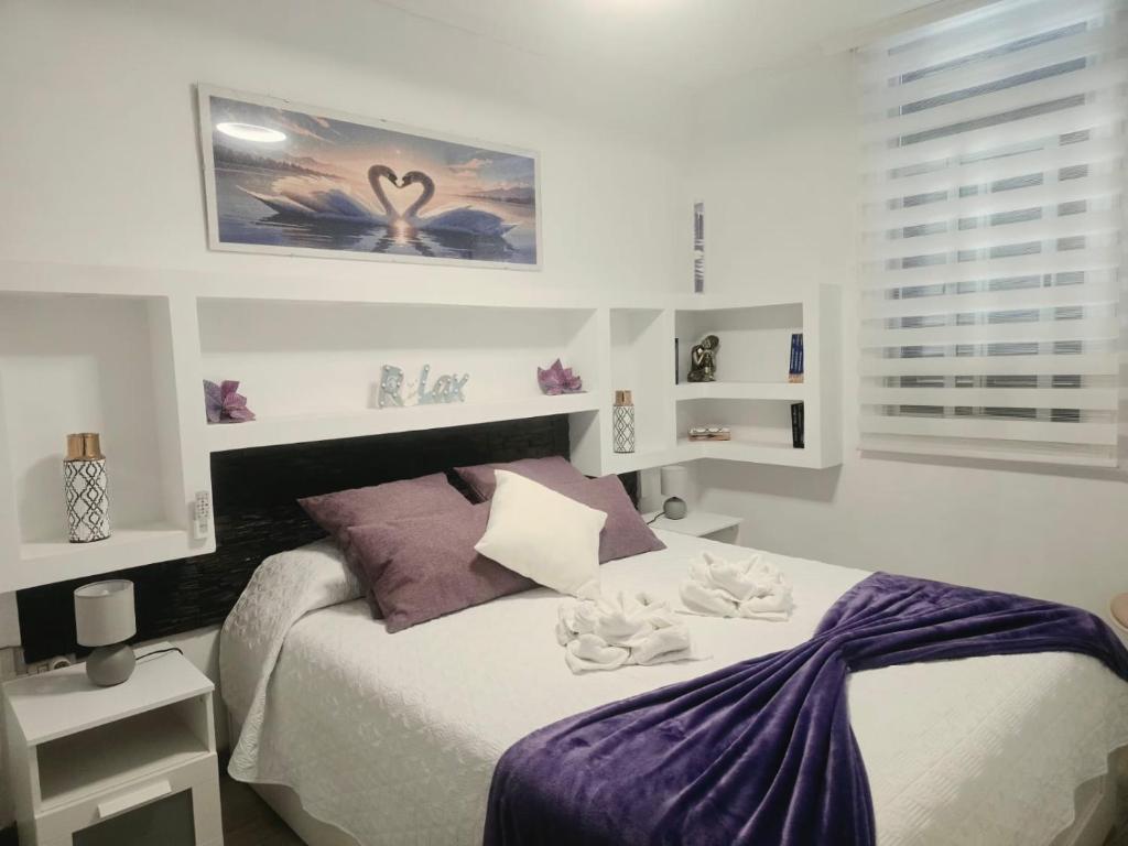 a bedroom with a bed with towels on it at Medano Time in El Médano