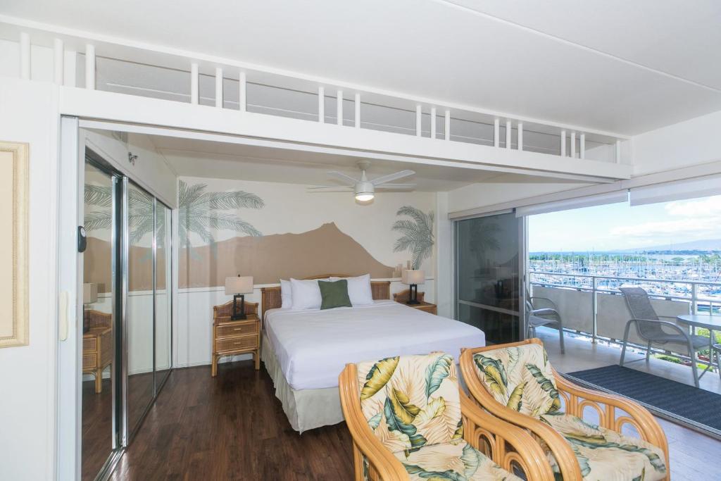 a bedroom with a bed and a balcony at Ilikai Tower 633 in Honolulu