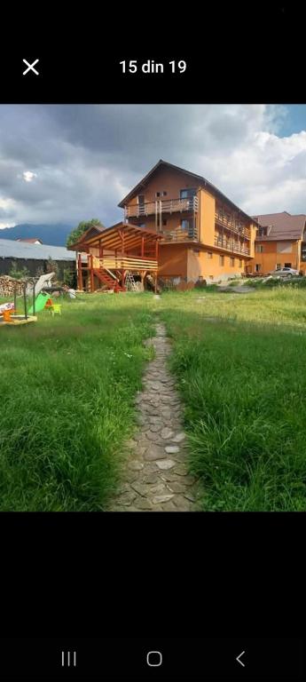 a picture of a house and a grass field at Vila Mihnea in Moieciu de Jos