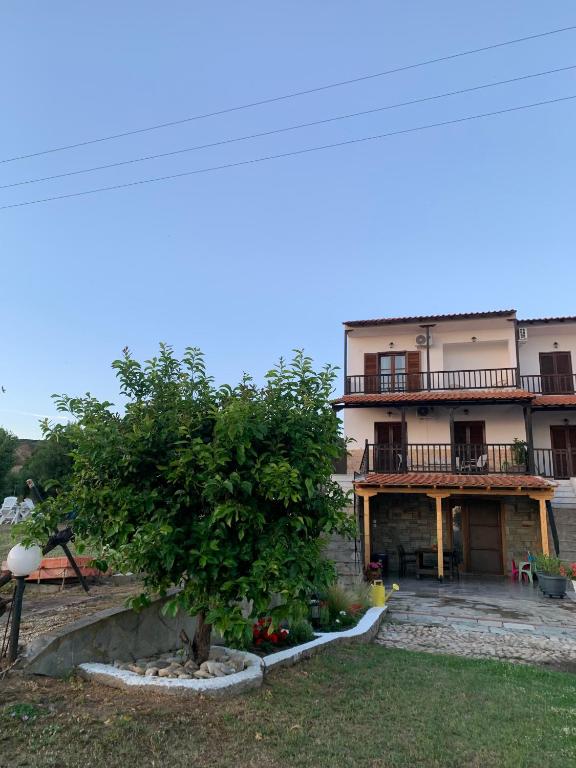 a large building with a tree in front of it at Athos Sea Villa in Ouranoupoli