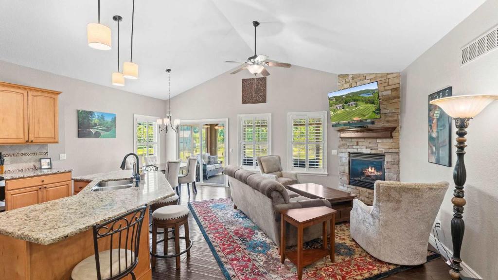 a kitchen and living room with a couch and a fireplace at TeeTime Green On the Fairway in Camdenton